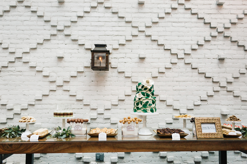 Beautiful industrial dessert table in front of a white brick wall at the Oxford Exchange