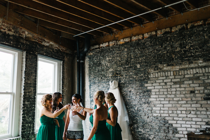 Bride toasting with her bridesmaids and laughing by Tampa Wedding Photographer