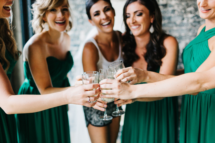 Candid wedding photography of the bride toasting with her bridesmaids at a downtown Tampa wedding