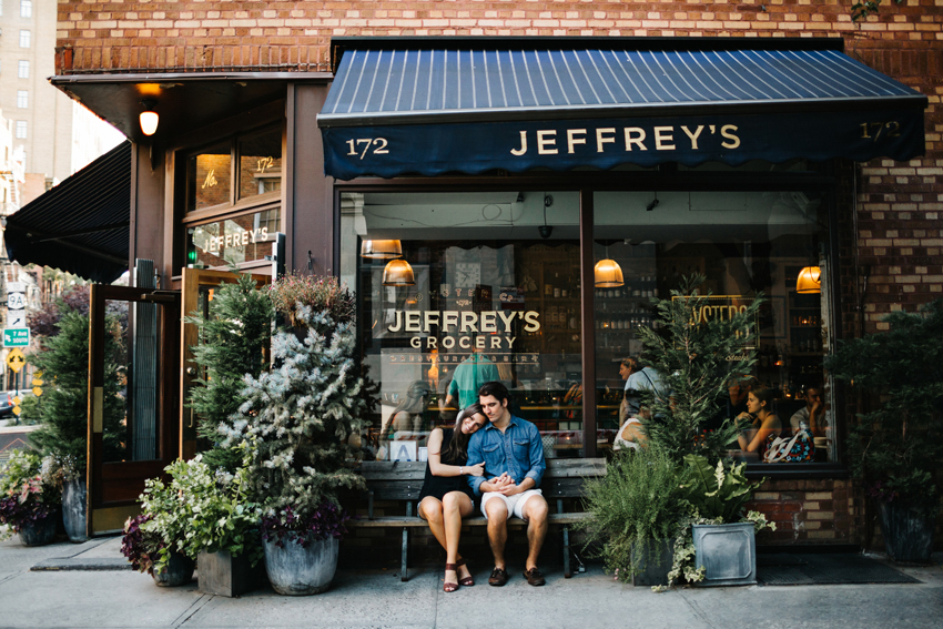 Couple snuggling at sunset in front of Jeffrey's Grocery in the West Village of New York City for there wedding engagement photos