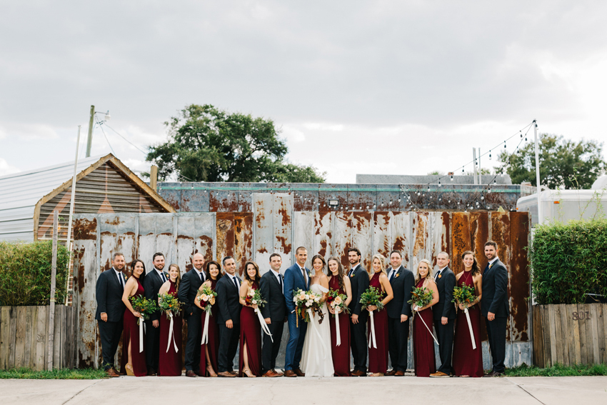 Bridal party standing in front of a modern rust backdrop at 801 East Main in downtown Lakeland