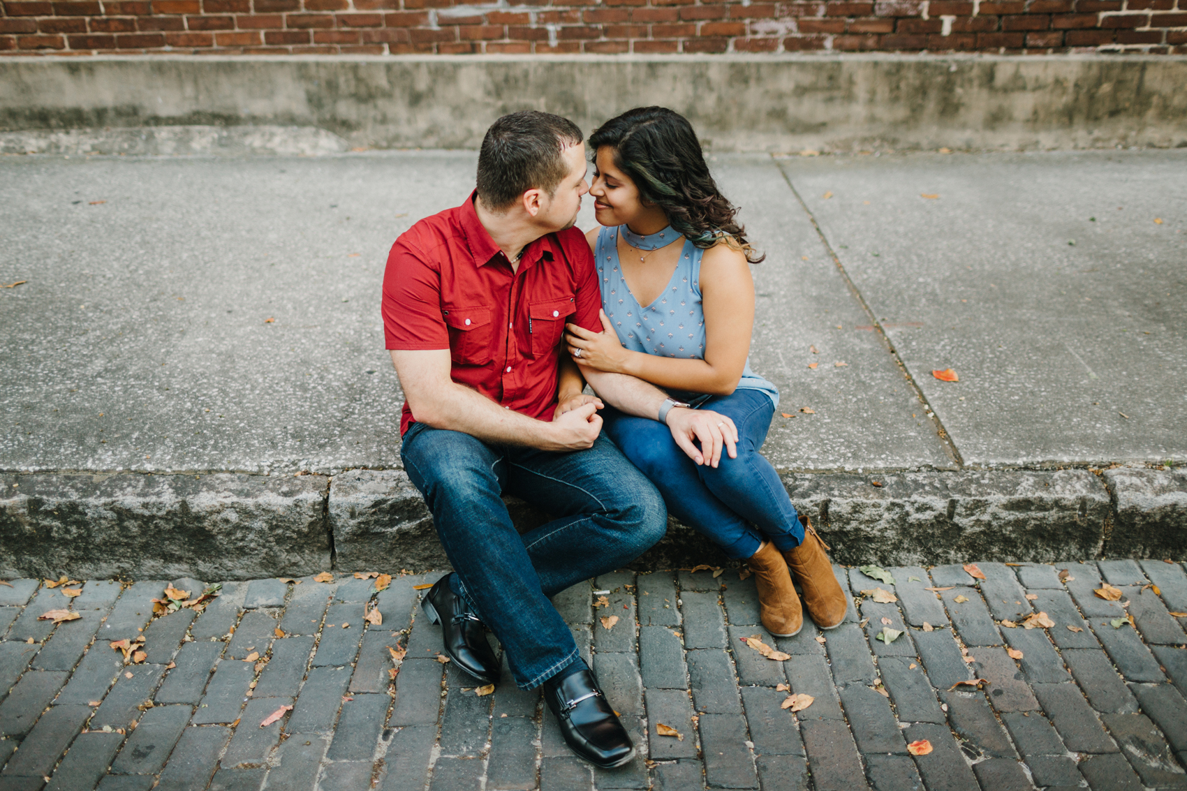 Sweet lifestyle engagement session of cute couple snuggling at sunset