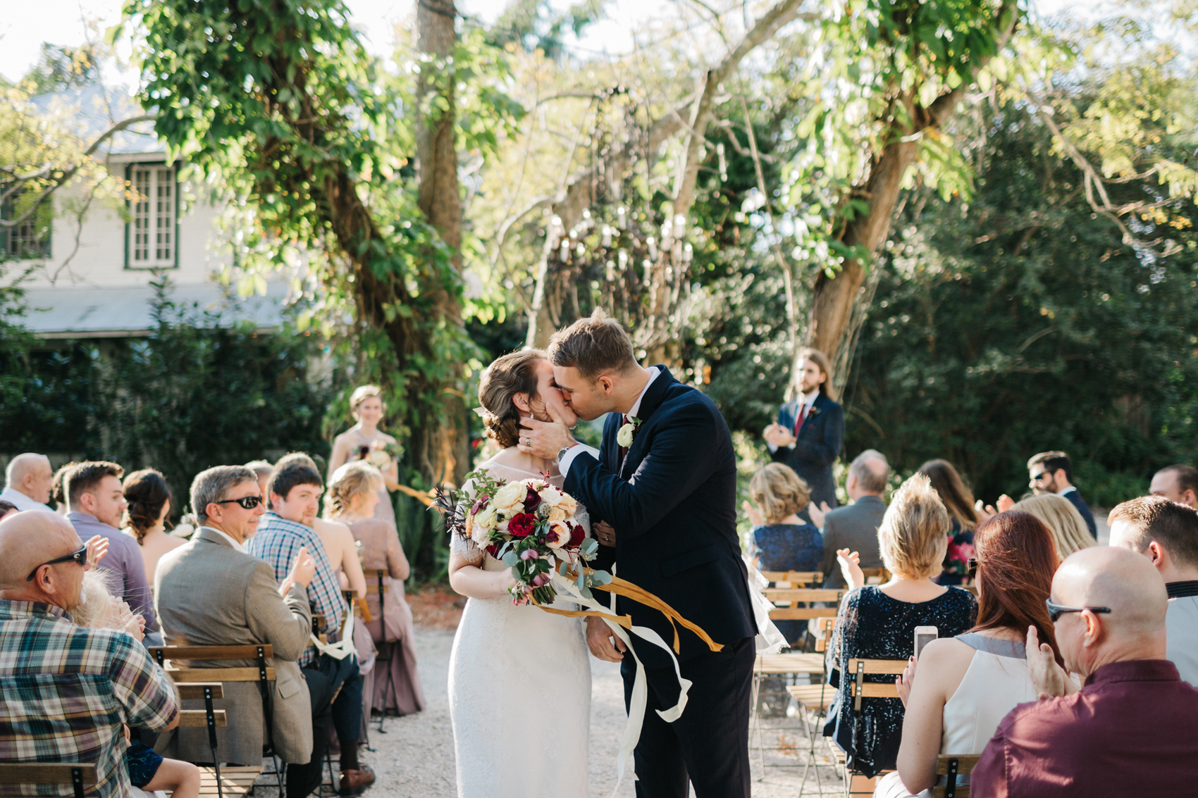 Bride and groom sharing their first kiss at the eclectic romantic secret garden ceremony
