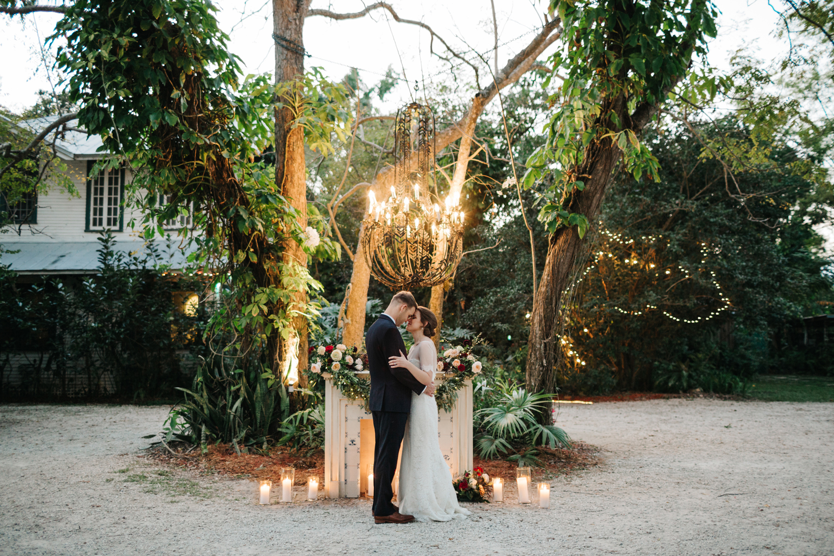 Romantic Orlando wedding photos at dusk with candles and stringlights in front of a vintage fireplace in the garden wedding