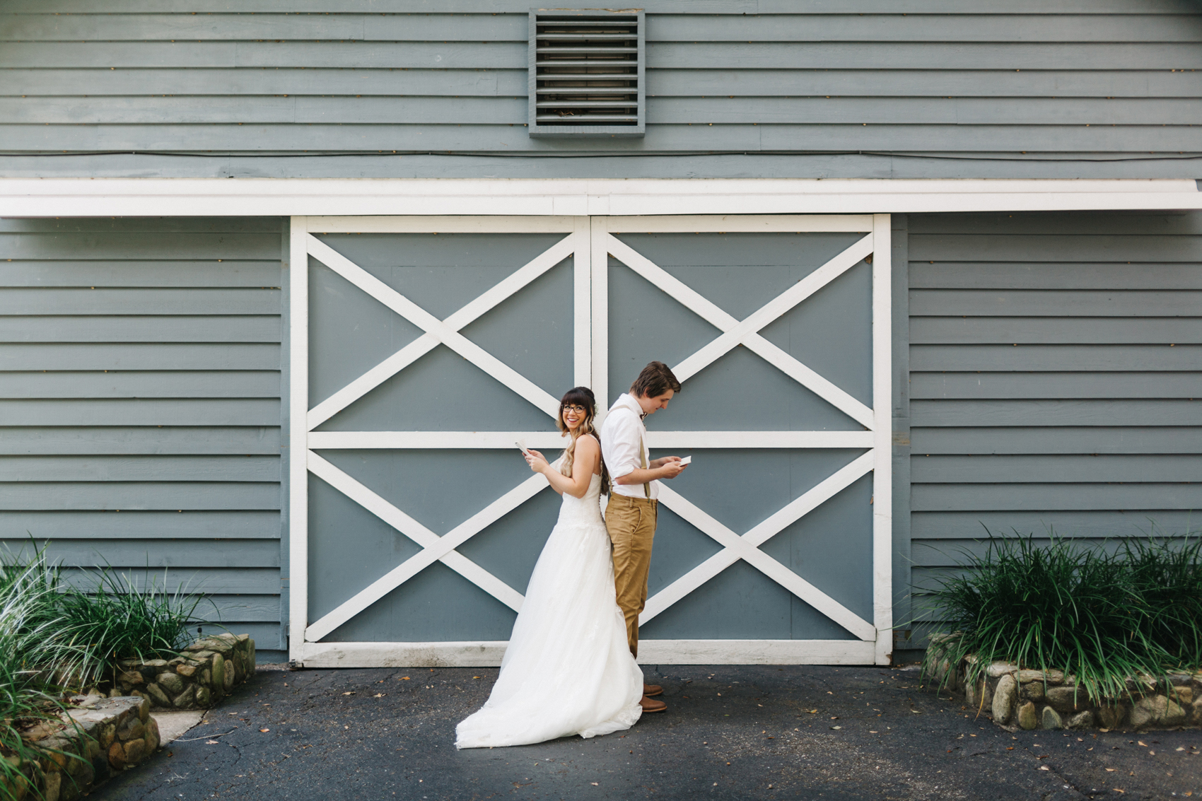 bride and groom sharing a sweet first look by exchanging letters infront of the dusty blue barn at the Lange Farm in Florida
