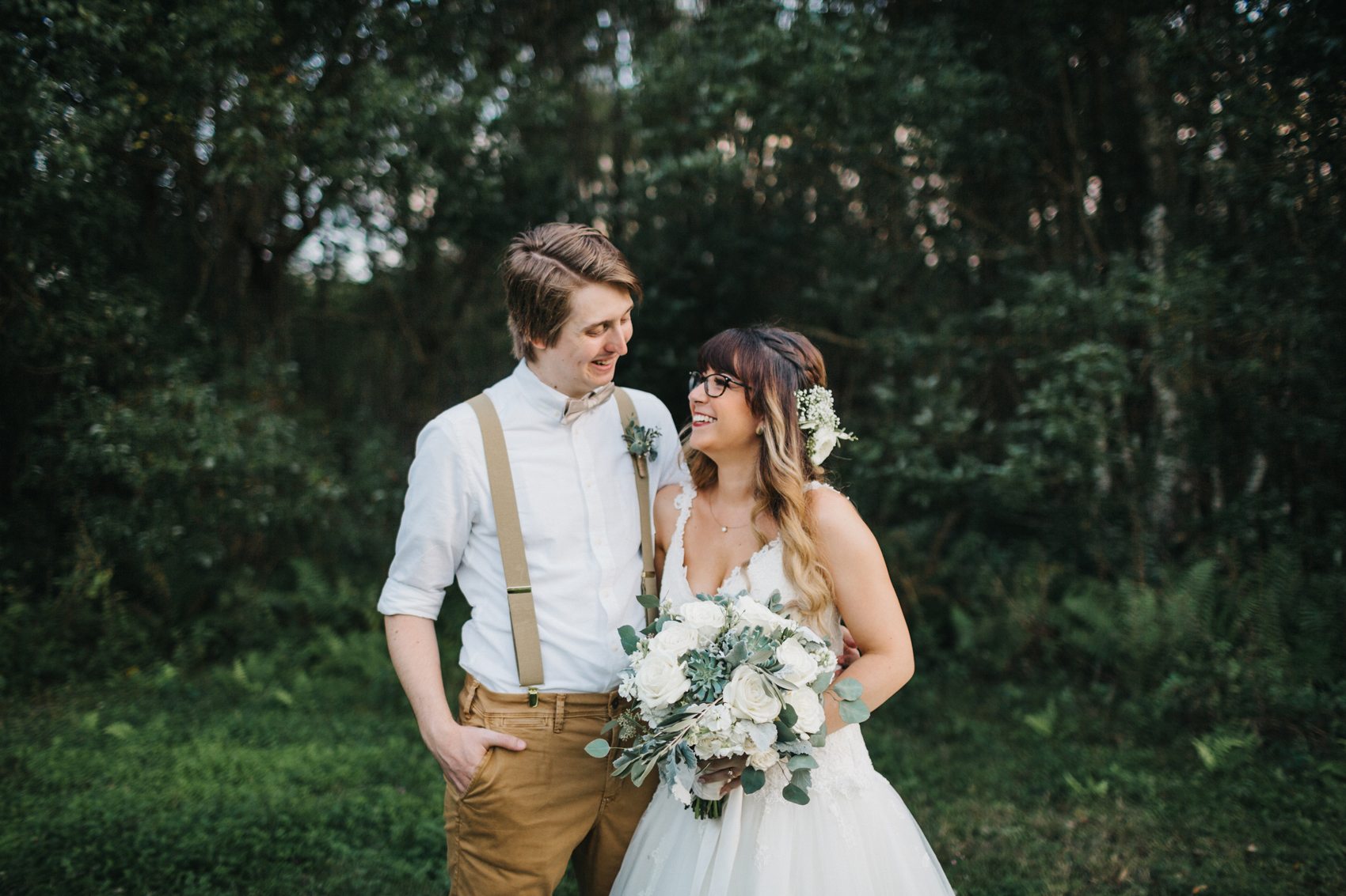 bride and groom laughing at sunset during their rustic farm wedding