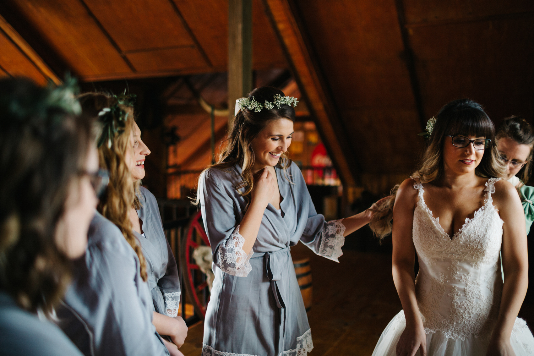 bridesmaids wearing floral crowns and grey robes while getting ready for rustic wedding
