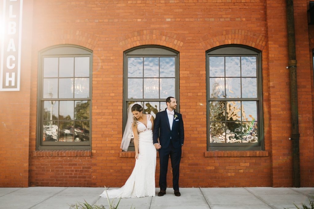 outdoor wedding photos in front of the exposed brick at Armature Works in downtown Tampa