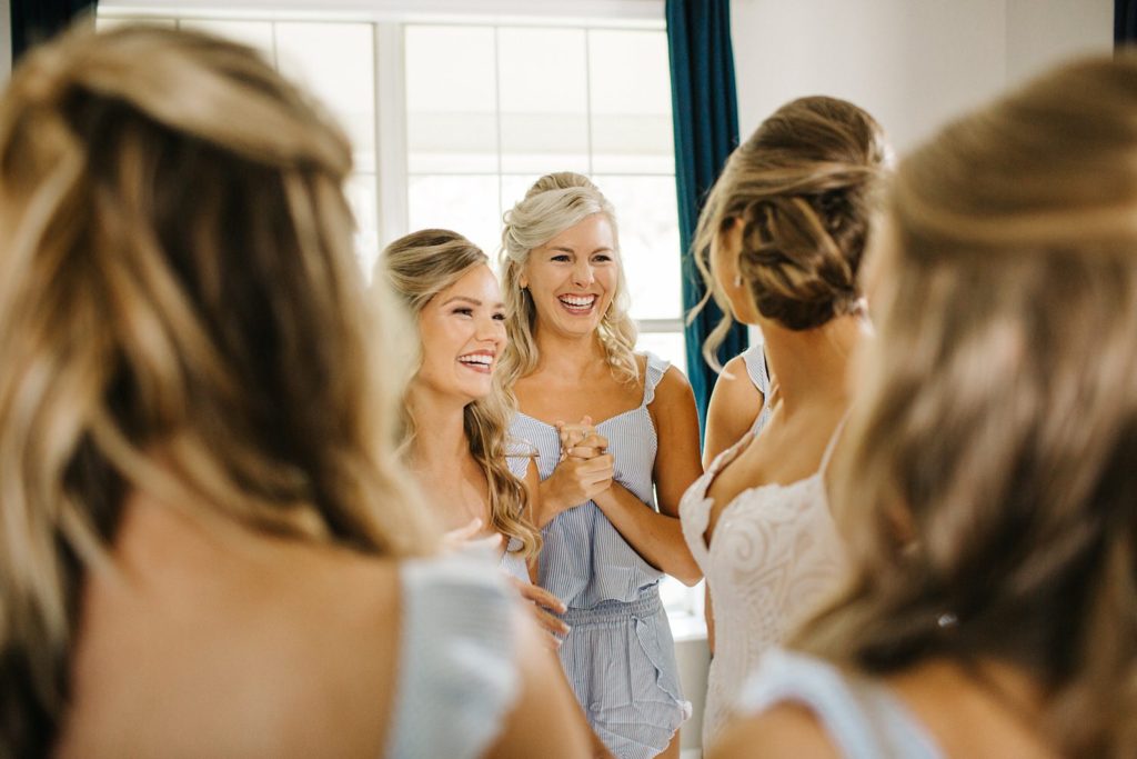bridesmaids helping the bride get dressed