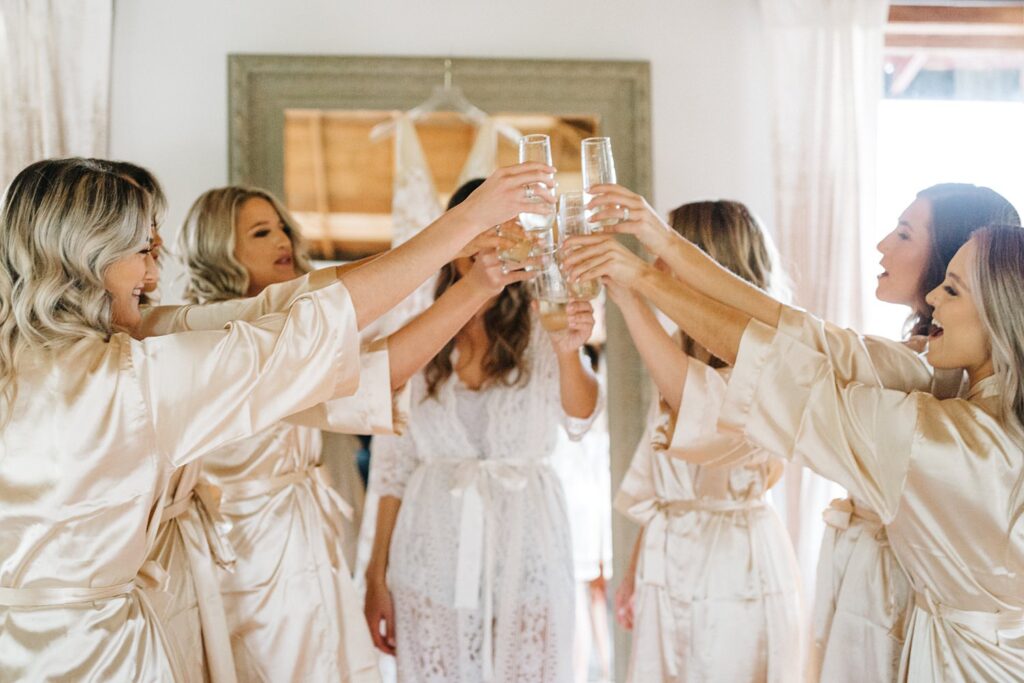 bridesmaids toasting the bride while wearing matching robes