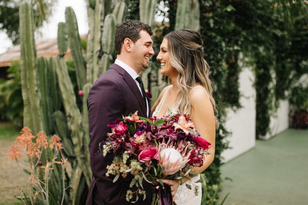bride and groom laughing in front of the cactus at The Acre wedding venue in Orlando