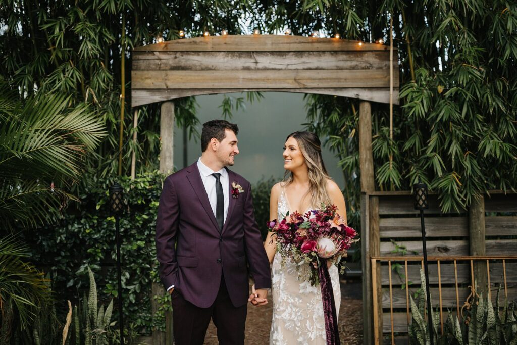 Wedding photos in front of the lush greenery at the boho wedding venue The Acre