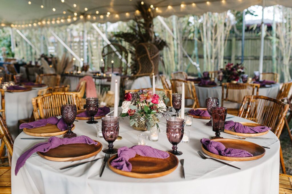 boho wedding reception decor with wooden chargers and purple glassware